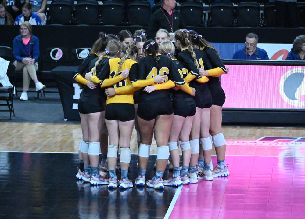 Picture of EBF Rocket volleyball team in a huddle at the state volleyball tournament