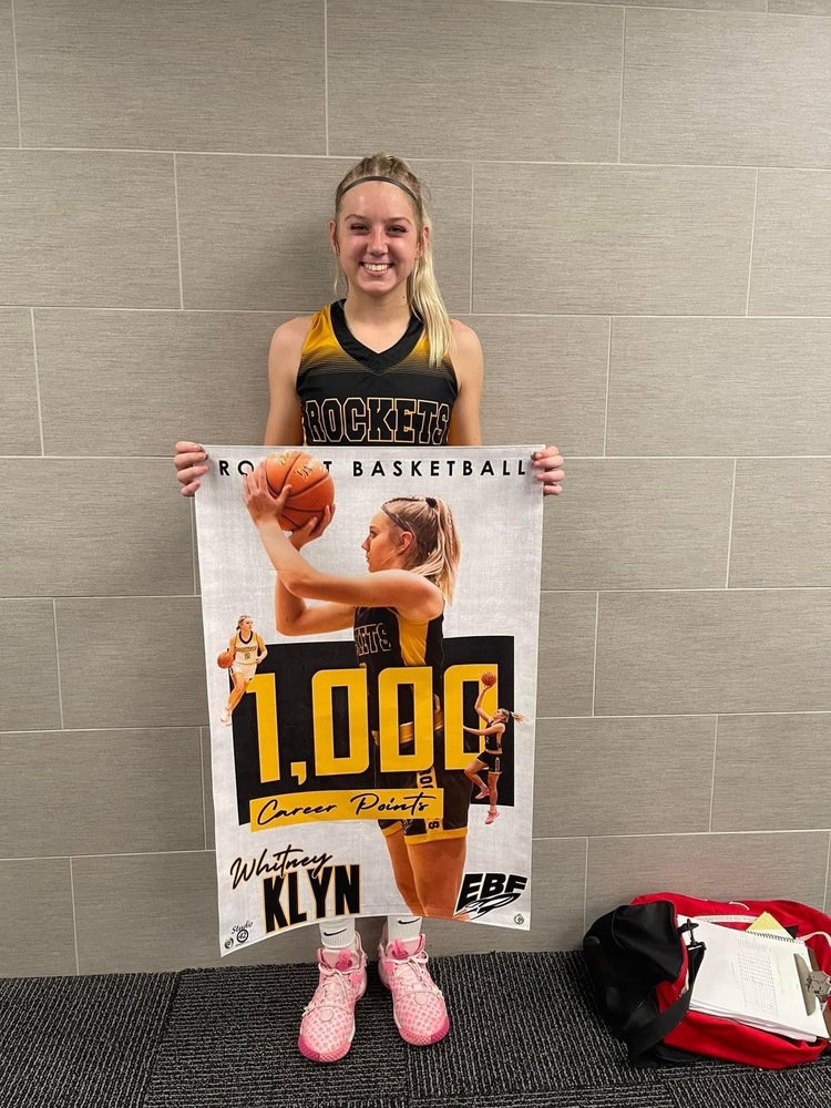 Picture of senior Whitney Klyn with her 1000th point banner